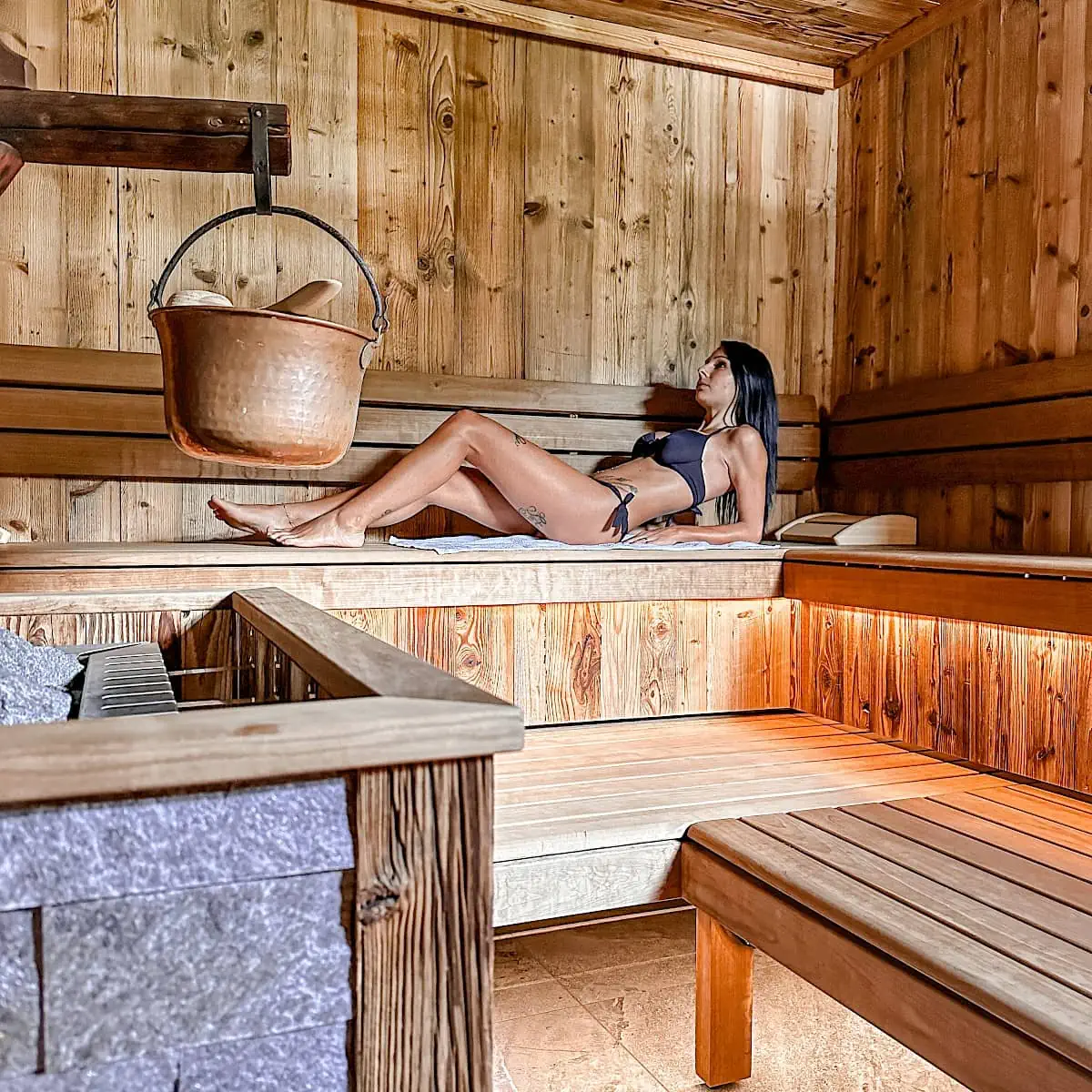 Vrouw in de sauna van het wellnesscentrum Zirmhof Apartments