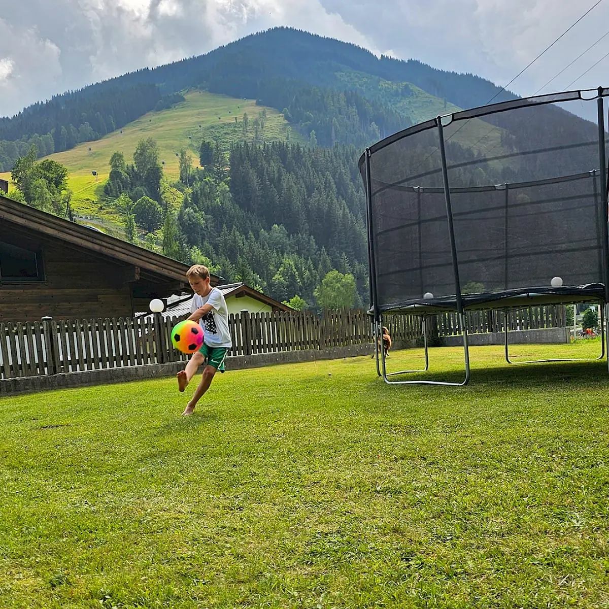 Junge spielt Fußball am Spieltplatz vom Zirmhof