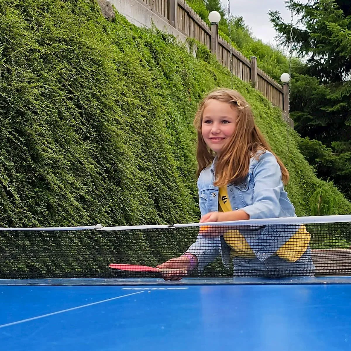 Mädchen spielt Tischtennis hinterm Zirmhof