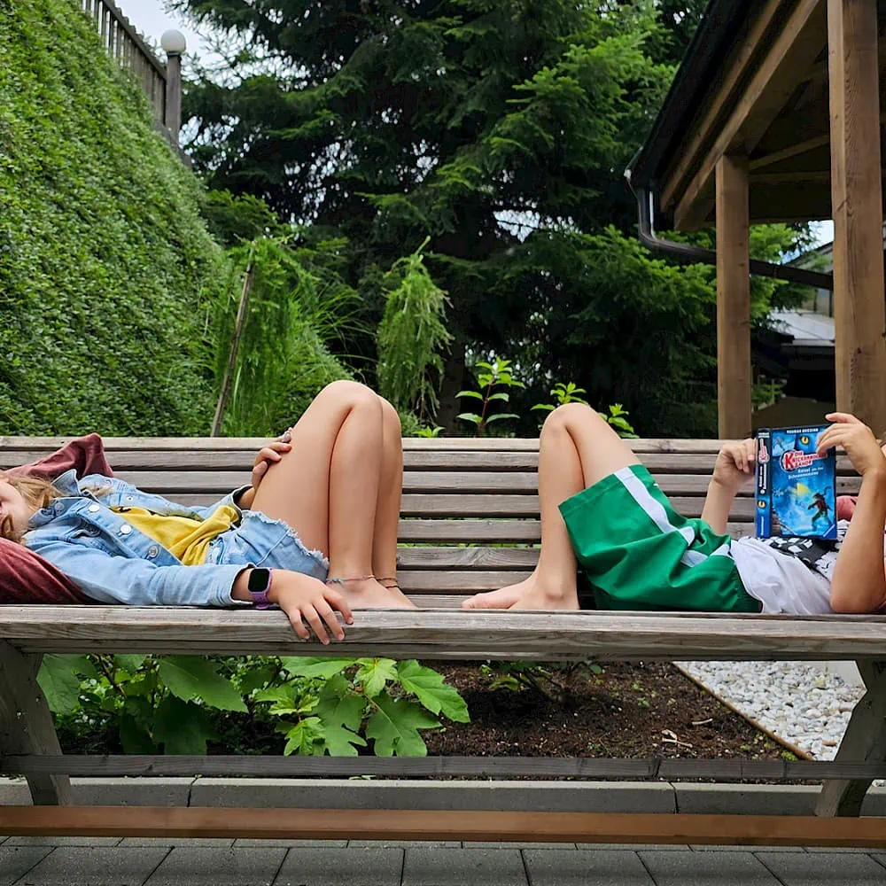 Girls and boys lie comfortably on the bench behind the Zirmhof